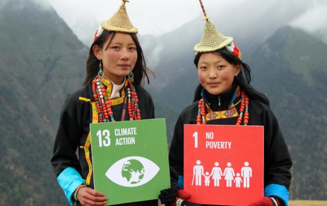 Deux femmes tenant des pancartes sur les SDG au Bouthan