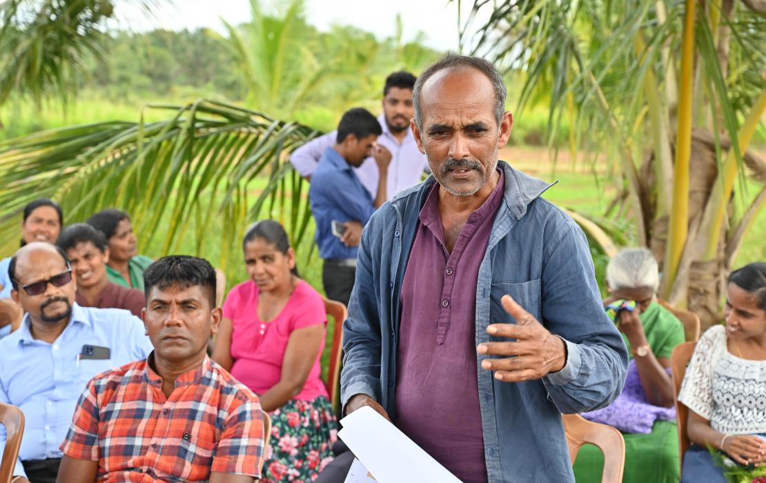 A man talks to other community members in Sri Lanka