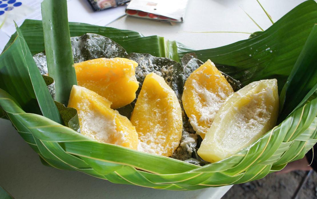Freshly cut mango in a bowl made with leaves.