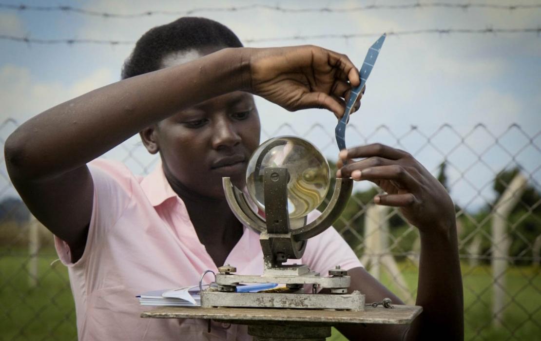 A woman taking measures with a transparent globe in Uganda