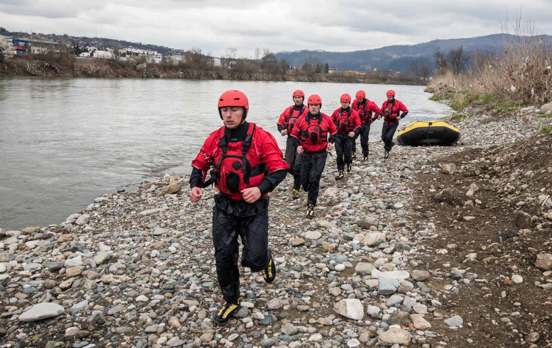 Men running next to river with rescue equipment in Bosnia and Herzegovina