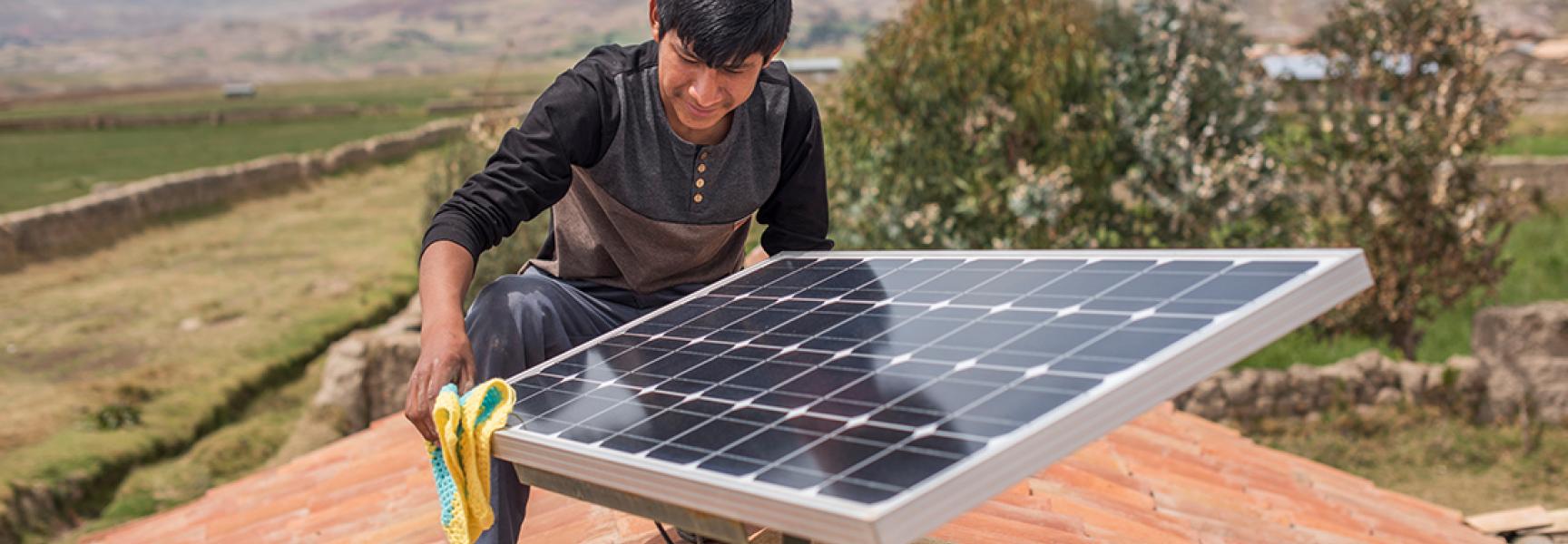 Une personne installant un panneau solaire au Pérou
