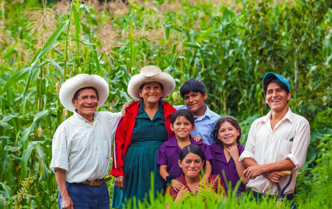 A farmer family in Peru smiling.