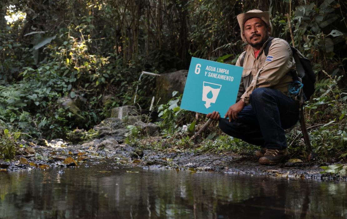 Hombre con cartel de ODS 6 de Agua y Saneamiento