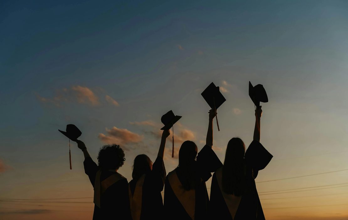 Estudiantes levantan sus gorras para celebrar su graduación