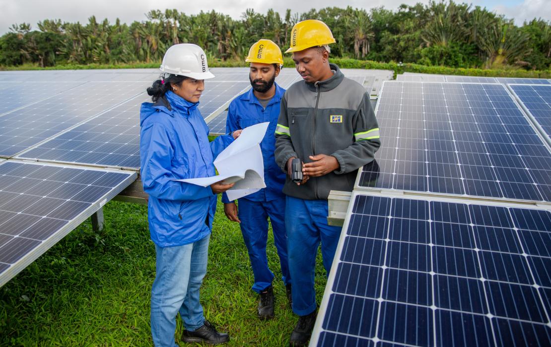 Femme ingénieur travaillant avec une équipe sur l'installation de panneaux solaires à l'île Maurice et aux Seychelles