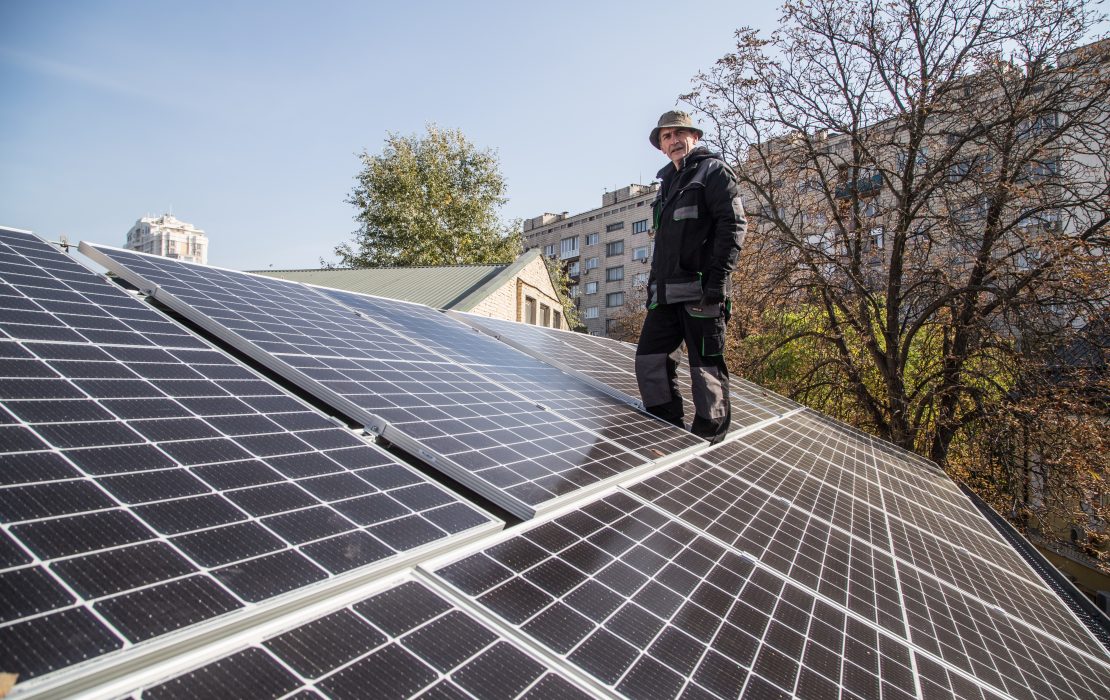 Worker surveys the installation of solar panels, Kyiv, Ukraine