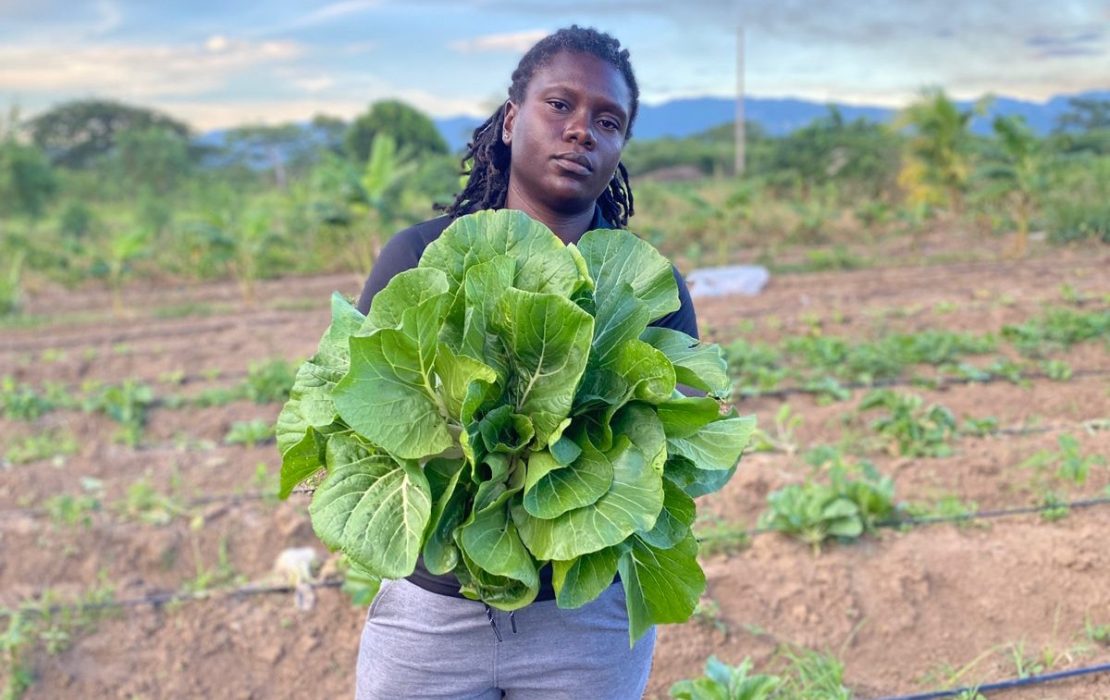 Tracey-Ann holding pak choy grown by the community. Photo: I-SEEED Youths Limited Tracey-Ann holding pak choy