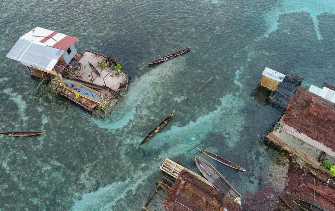 Aerial view of coastal home surrounded by water.