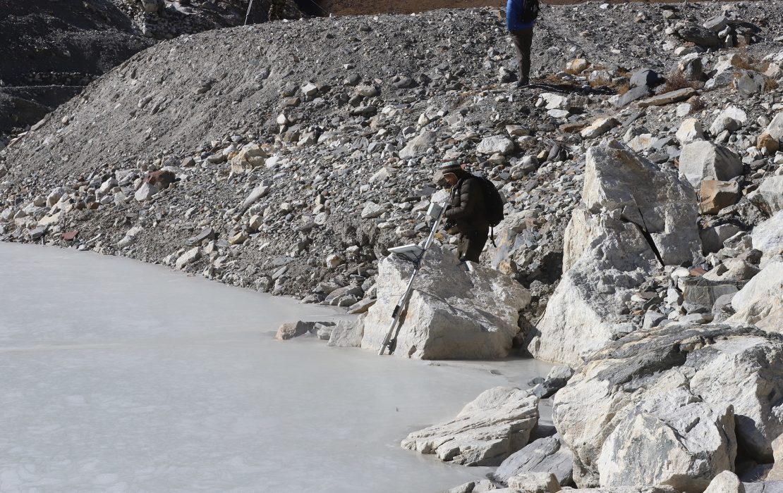 A technician installs an early warning radar along the edge of Imja Lake in Nepal’s Himalayas to monitor potential glacial lake outburst floods. 