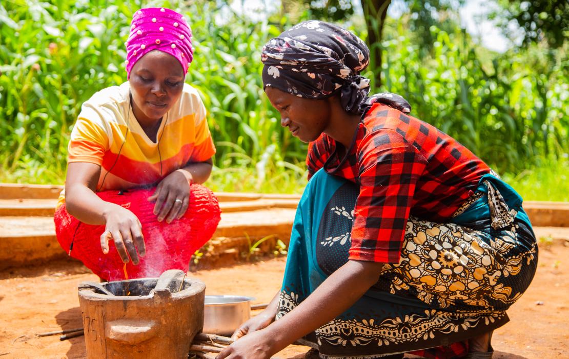 Two women learning how to use new cookstoves. 