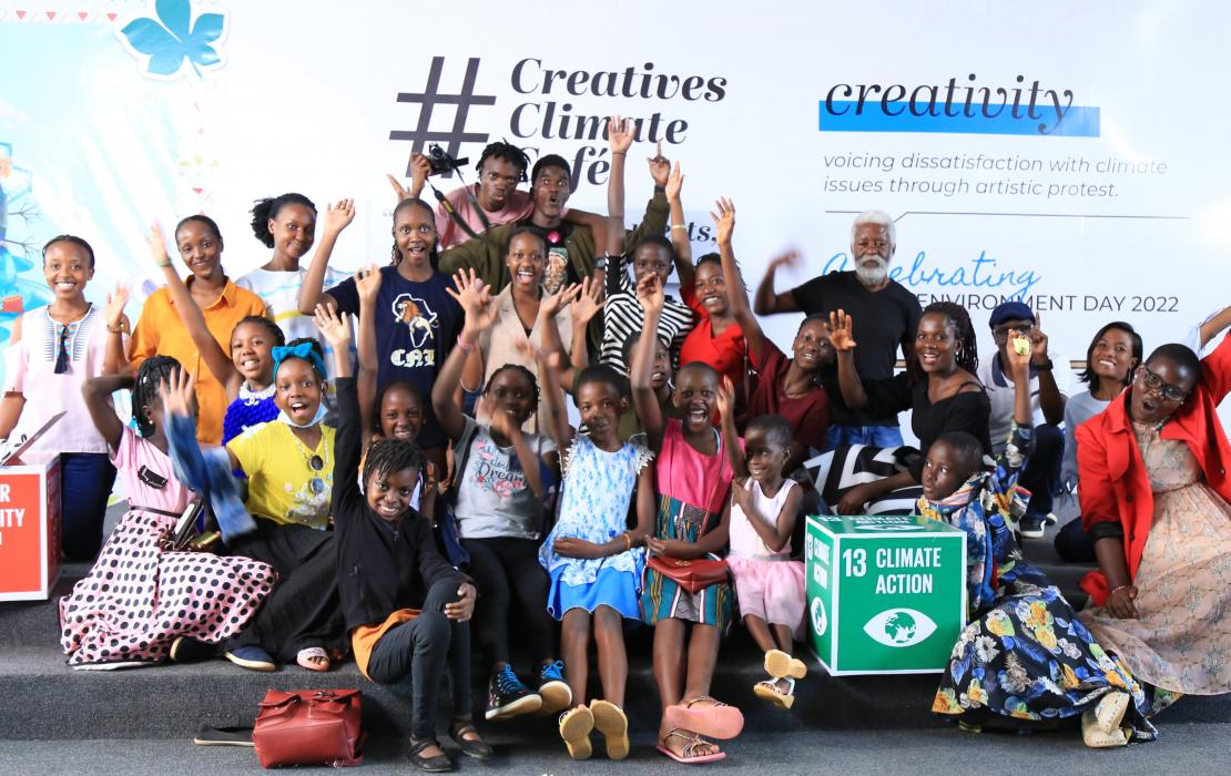 JulietGrace and children at the Creatives Climate Café. Photo: Philip Mwebaza JulietGrace posing with children at the Creatives Climate Café.