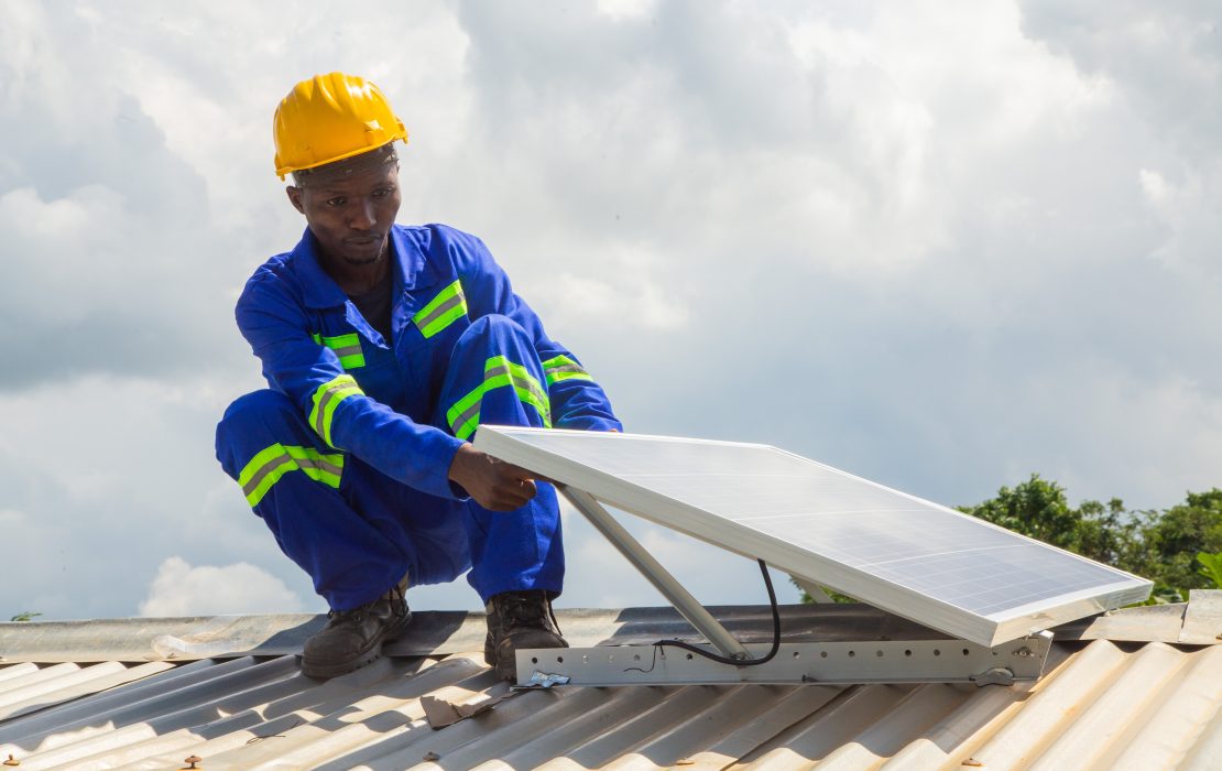 Man installing a solar panel in Malawi