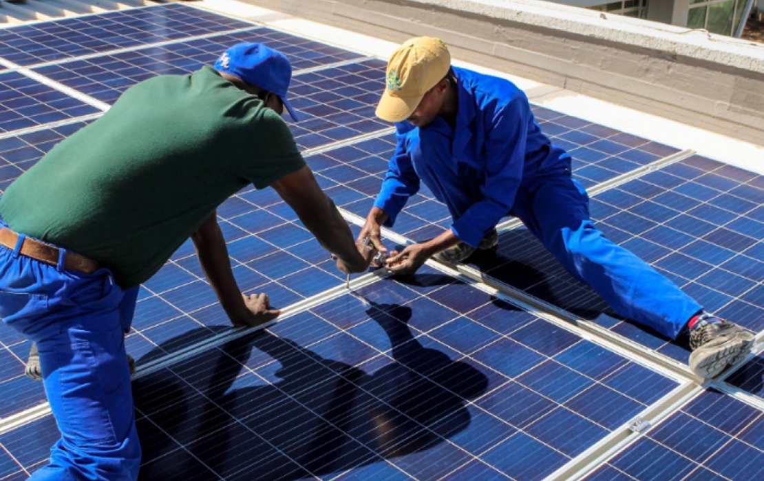 Deux hommes installant des panneaux solaires au Ghana