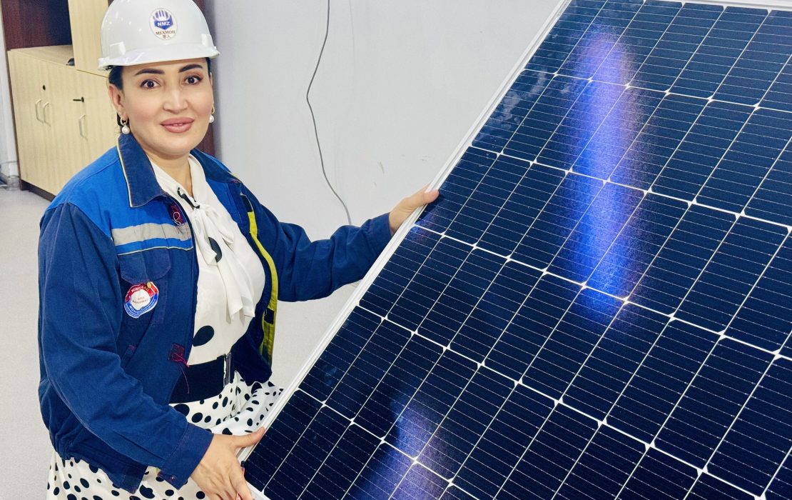 Woman engineers in Uzbekistan help drive the country’s transition to renewable energy. Photo: UNDP Uzbekistan. Photo: UNDP Uzbekistan A woman engineer in Uzbekistan wearing a hard hat and work jacket, holding a large solar panel as part of a renewable energy initiative