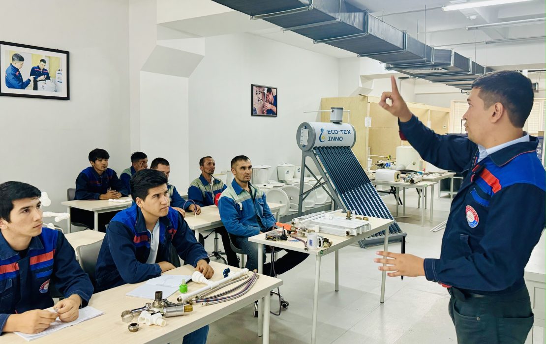 Electricians and plumbers taking part in a training on renewable energy installations in a monocenter. Photo: UNDP Uzbekistan A group of trainees in Uzbekistan attending a renewable energy and plumbing technology class, with an instructor explaining equipment for solar water heating systems.