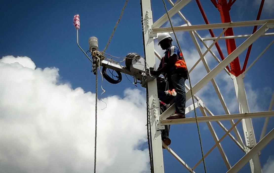 Un technicien réparant une installation de captation de données climatiques en Ouganda