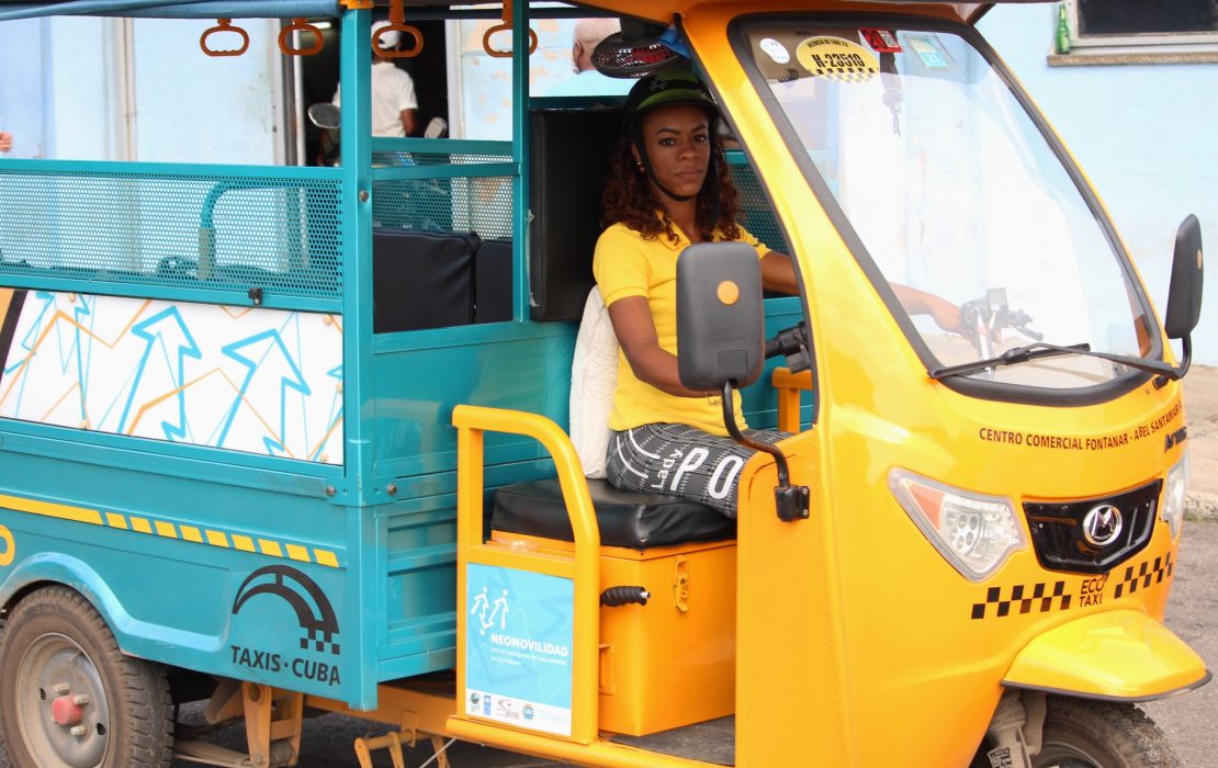 Woman driving an electric rickshaw in Cuba