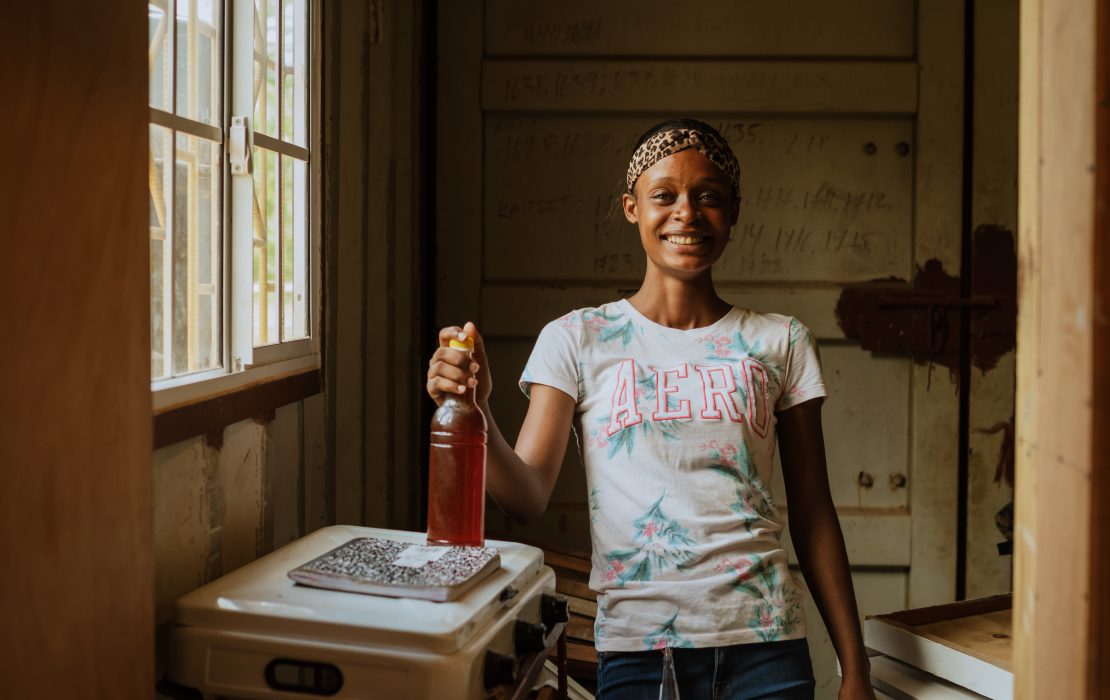 A green future could also positively impact Jamaica's GDP, generating up to 7,500 new jobs, including more jobs available for women and youth. Young woman in Jamaica holding a bottle of honey