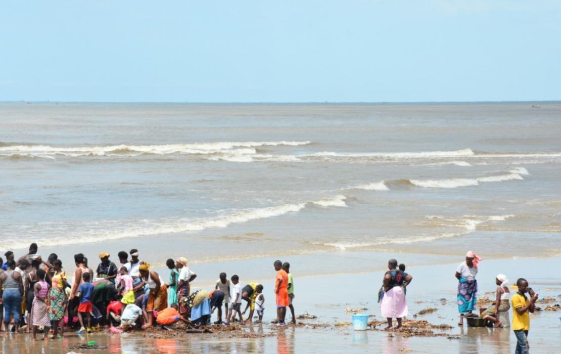 People waiting for fishermen on a beach in Liberia