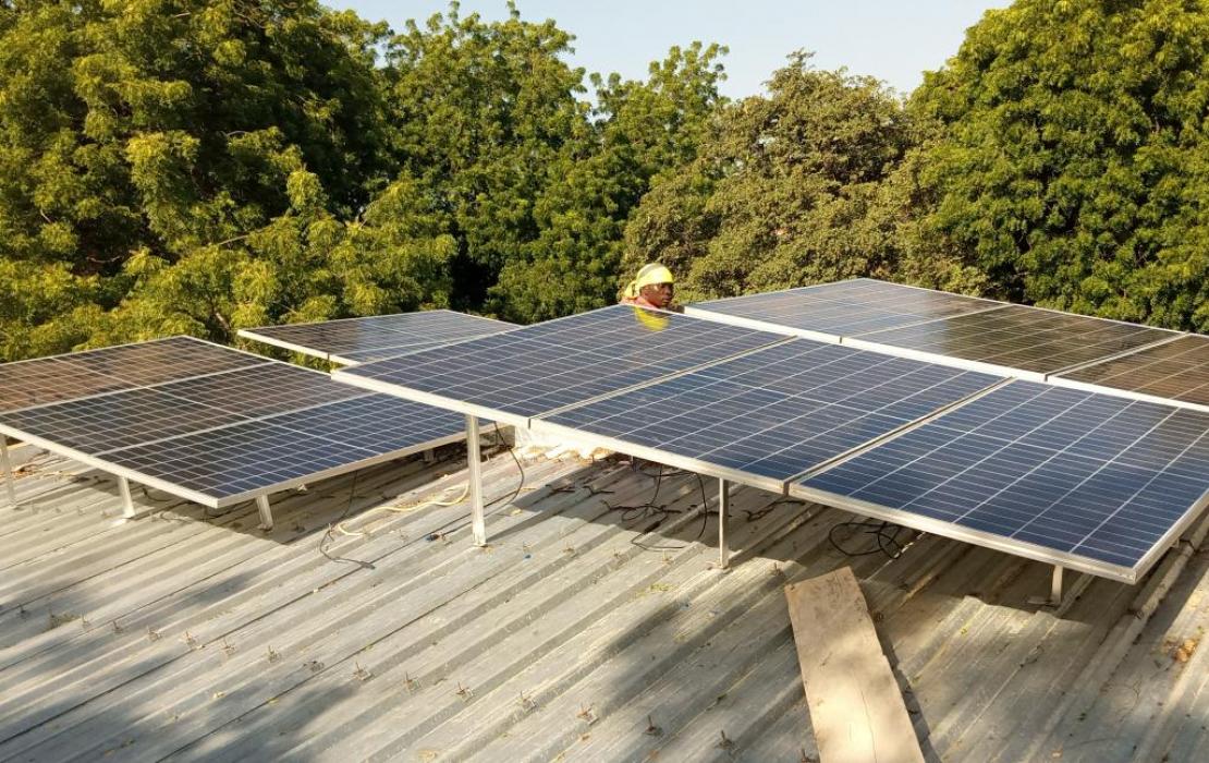 A woman next to a solar panel in Burkina Faso. Photo: UNDP Burkina Faso