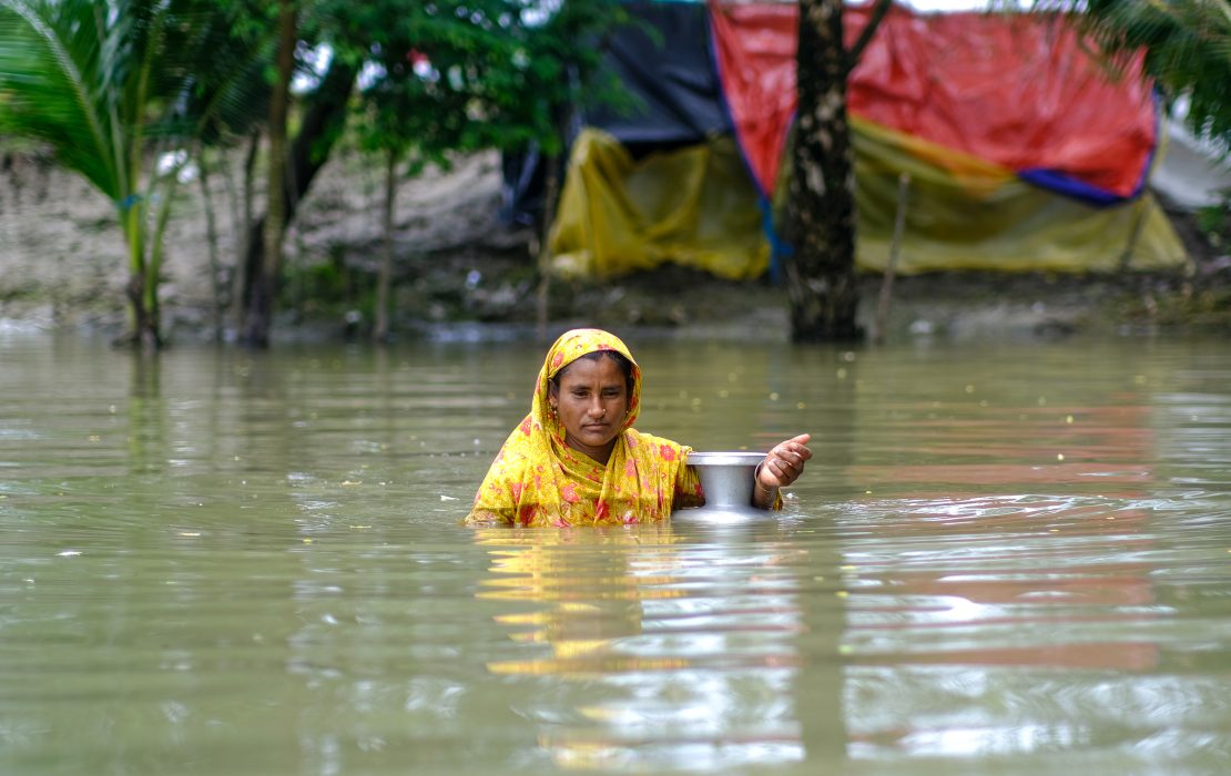 A woman wades through floodwaters in coastal Bangladesh.