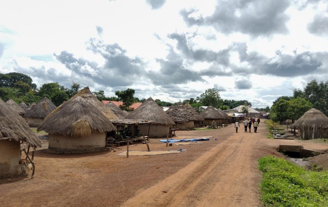 Une route qui longe un village reculé en Guinée