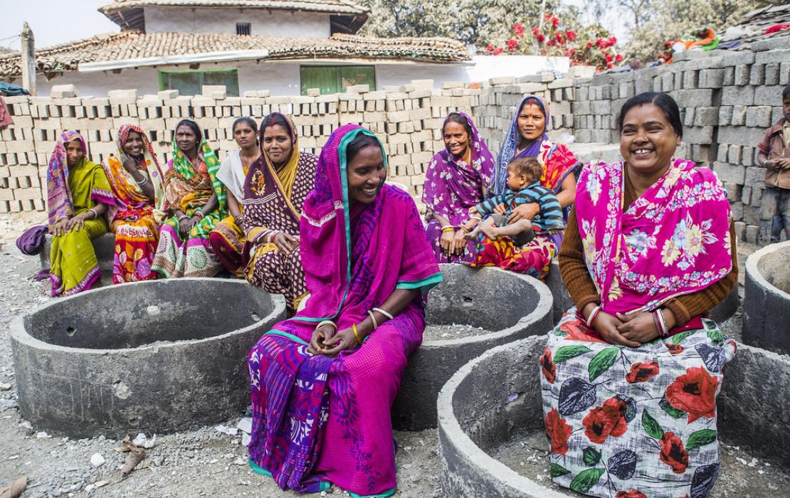 Women in India sitting as a group and smiling