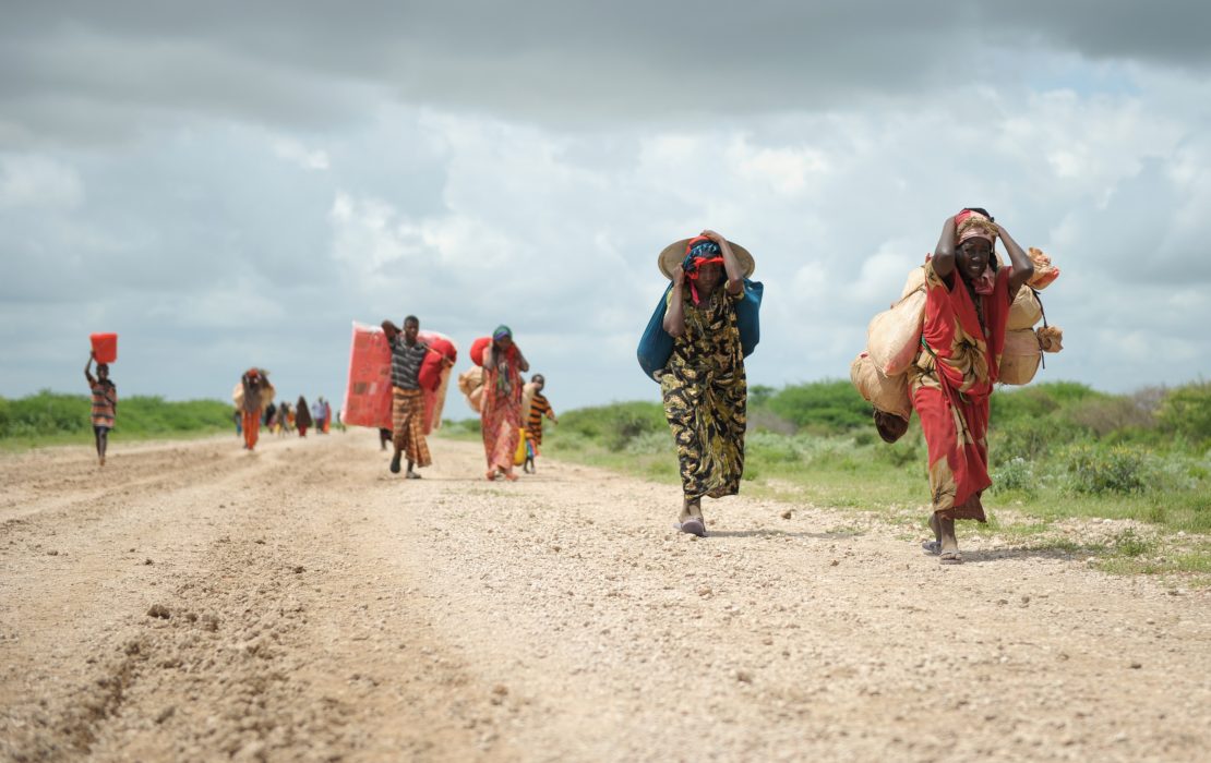 Carrying whatever possessions they can, women arrive in a steady trickle at a camp for Internally Displaced People (IDPs).