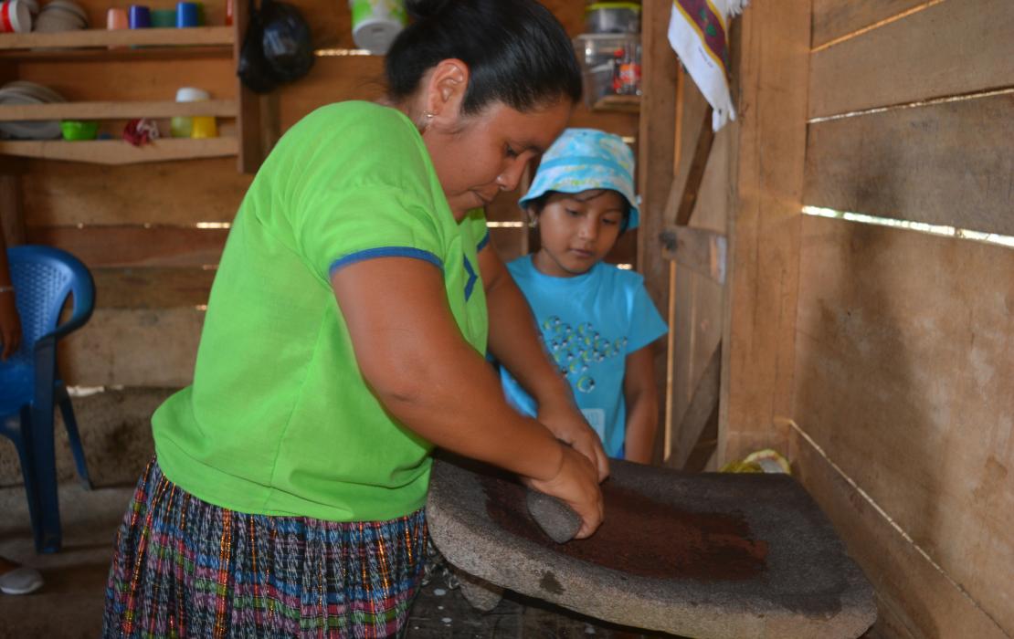 Woman grinding cacao beans in Belize