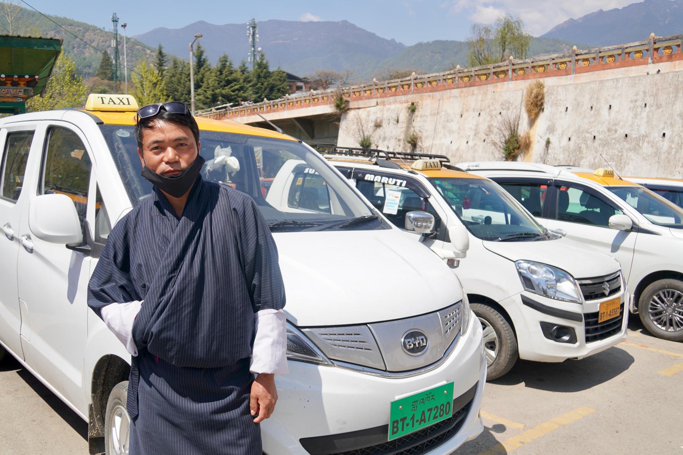 A taxi operator in Bhutan in front of his new EV