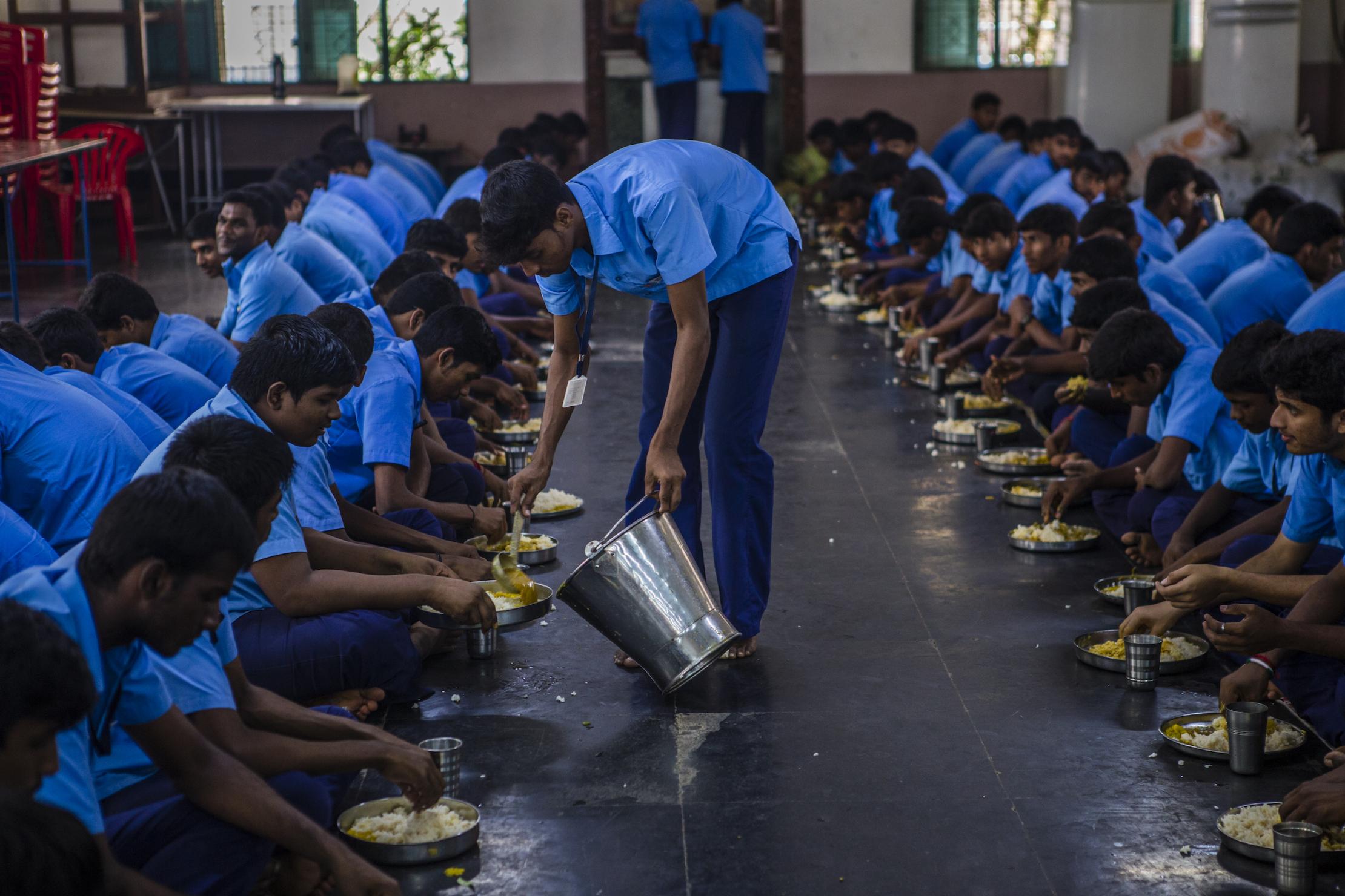 Students from India eat lunch cooked with the steam generated from a solar energy-based steam generator