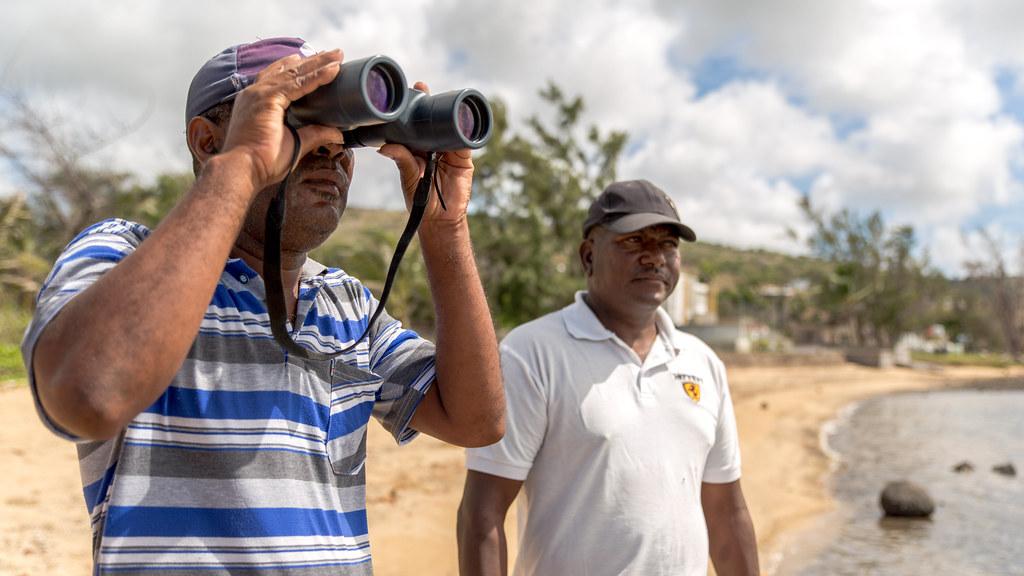 Two men  looking at the horizon on a beach in Seychelles