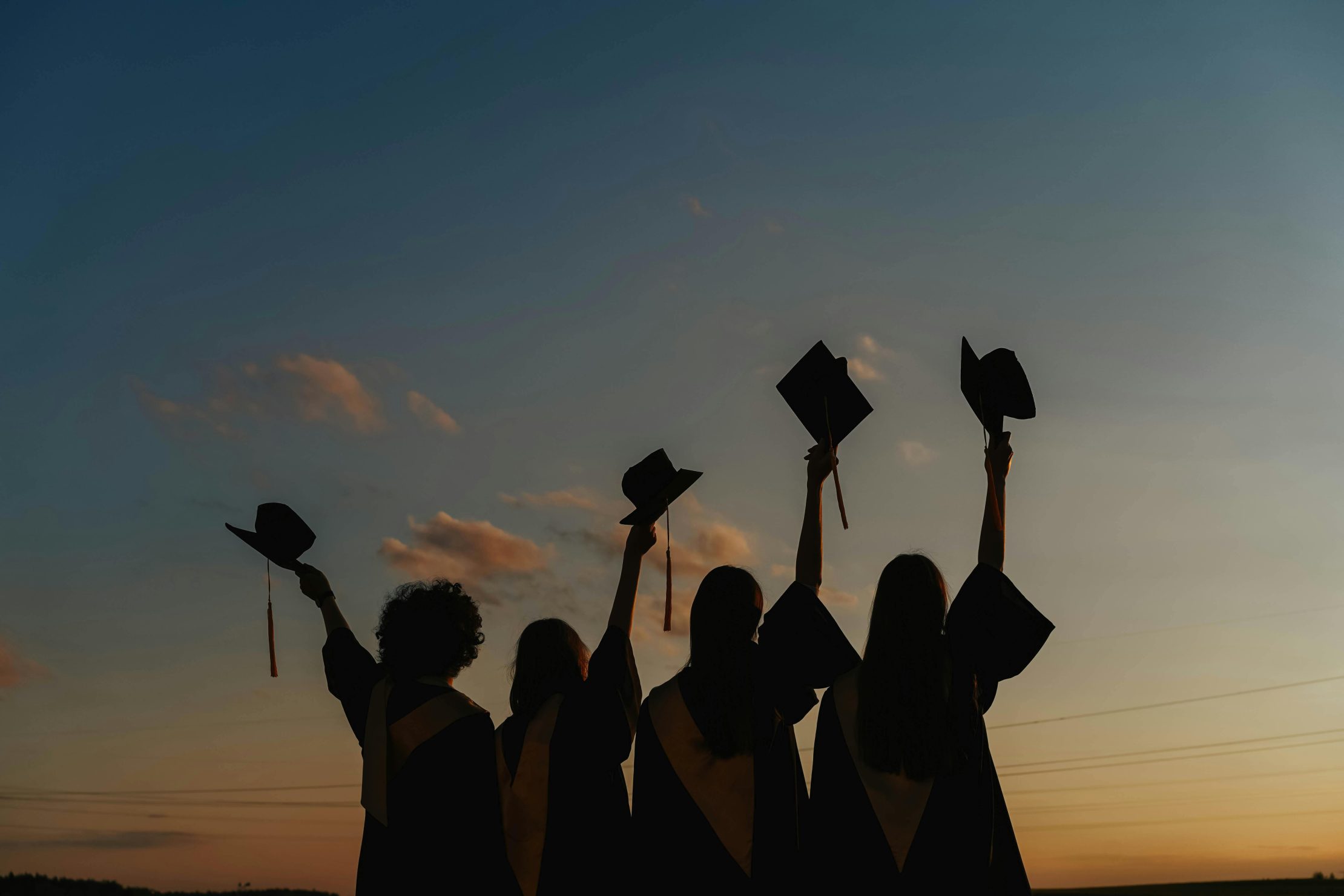 University graduates raising their caps in celebration 