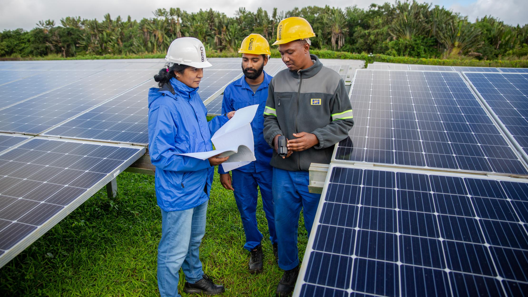 Femme ingénieur travaillant avec une équipe sur l'installation de panneaux solaires à l'île Maurice et aux Seychelles