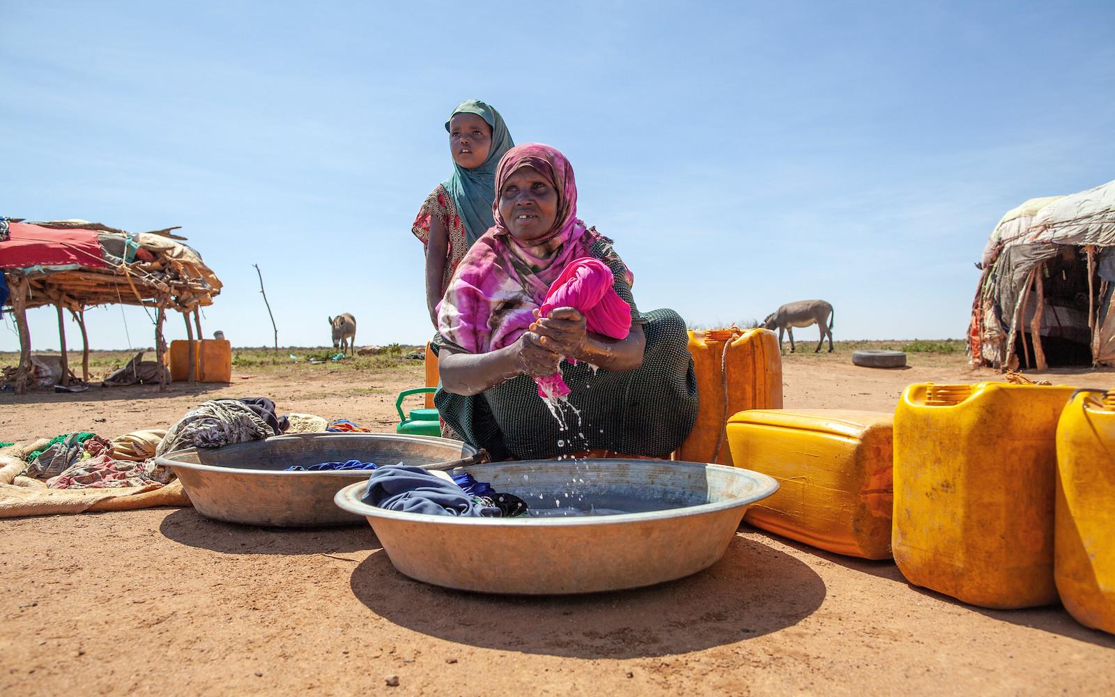 Fardosa Mohamed, a 50-year-old pastoralist, washes clothes at home using water she’s collected from the UNDP-funded dam in Baligubadle.