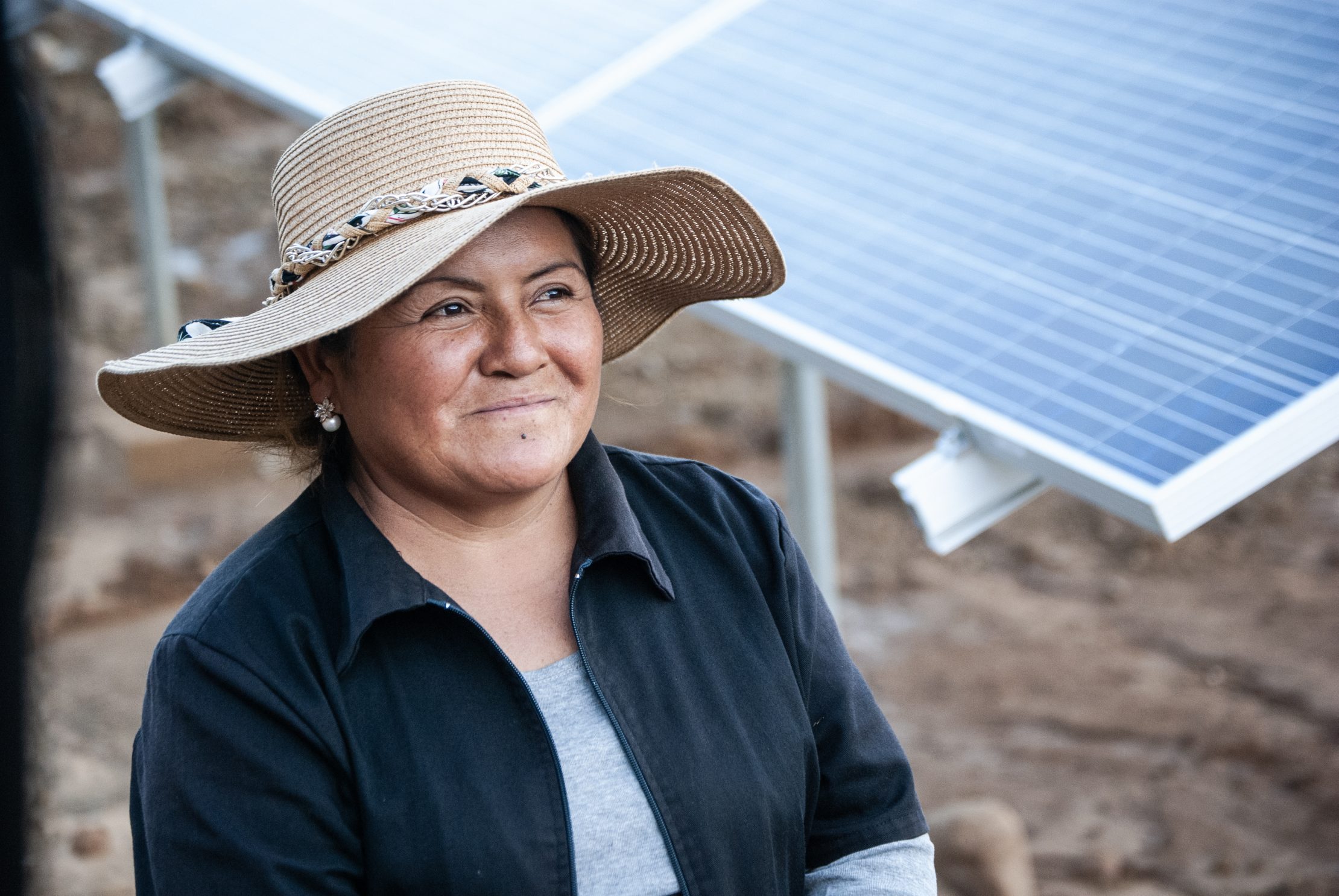 Woman standing next to a solar panel in Bolivia