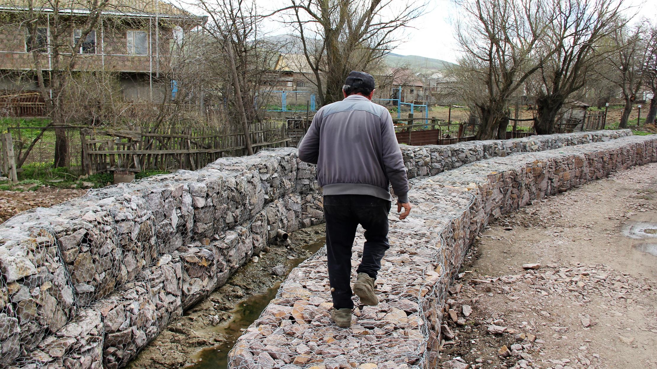 Man walking on protective structures against mudflows in Armenia