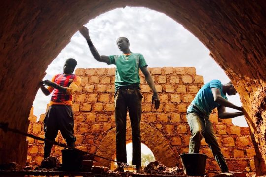 Three men work in the construction of Nubian Vault houses using a technique originating in upper Egypt