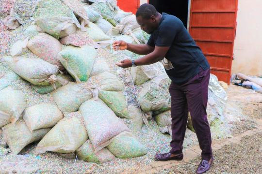 Nelson Boateng, fondateur de Nelplast Ghana, inspecte les granulés de plastique qui seront transformés en briques et en pavés et utilisés comme matériaux de construction.