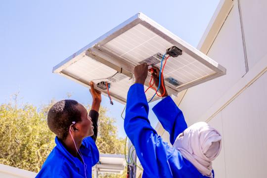 Two men installing solar panels in Niger