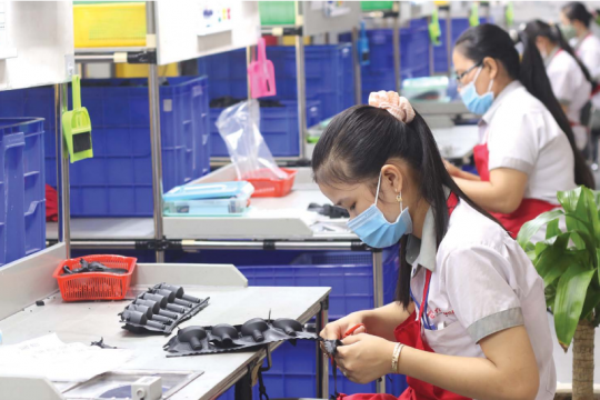 Photo: Le Toan on www.vir.com.vn | March 21-27, 2022 A woman is working at a factory