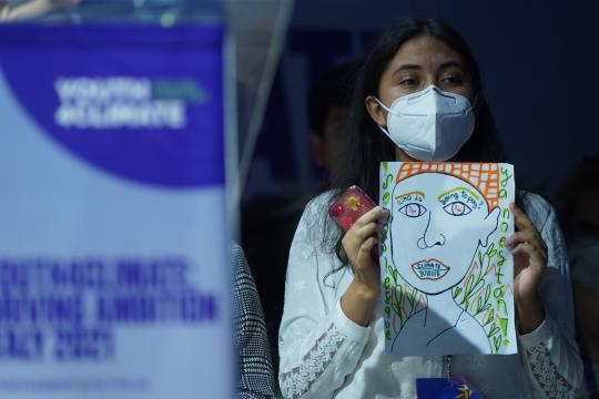 Joven mujer sosteniendo un cartel en una conferencia