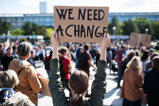 Crowd of young people holding signs for climate action