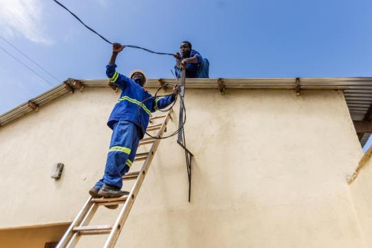 Two men installing a solar energy installation in Malawi.