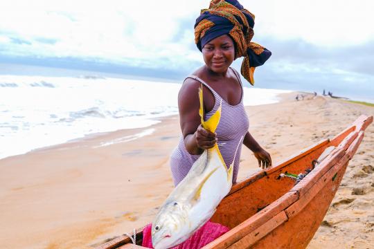 Photo : PNUD Sierra Leone Une femme montrant le poisson qui vient d'être pêché en Sierra Leone