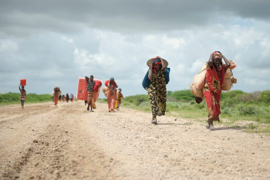 Carrying whatever possessions they can, women arrive in a steady trickle at a camp for Internally Displaced People (IDPs).