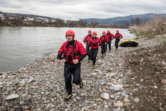 Men running next to river with rescue equipment in Bosnia and Herzegovina