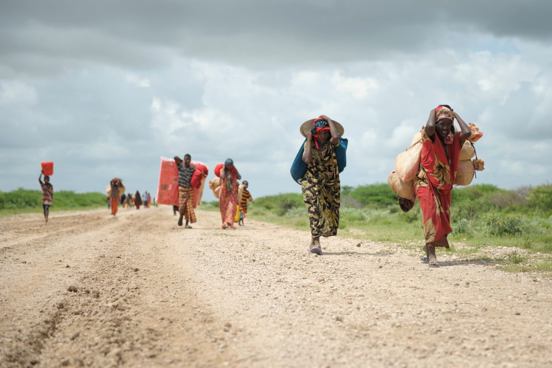 Carrying whatever possessions they can, women arrive in a steady trickle at a camp for Internally Displaced People (IDPs).