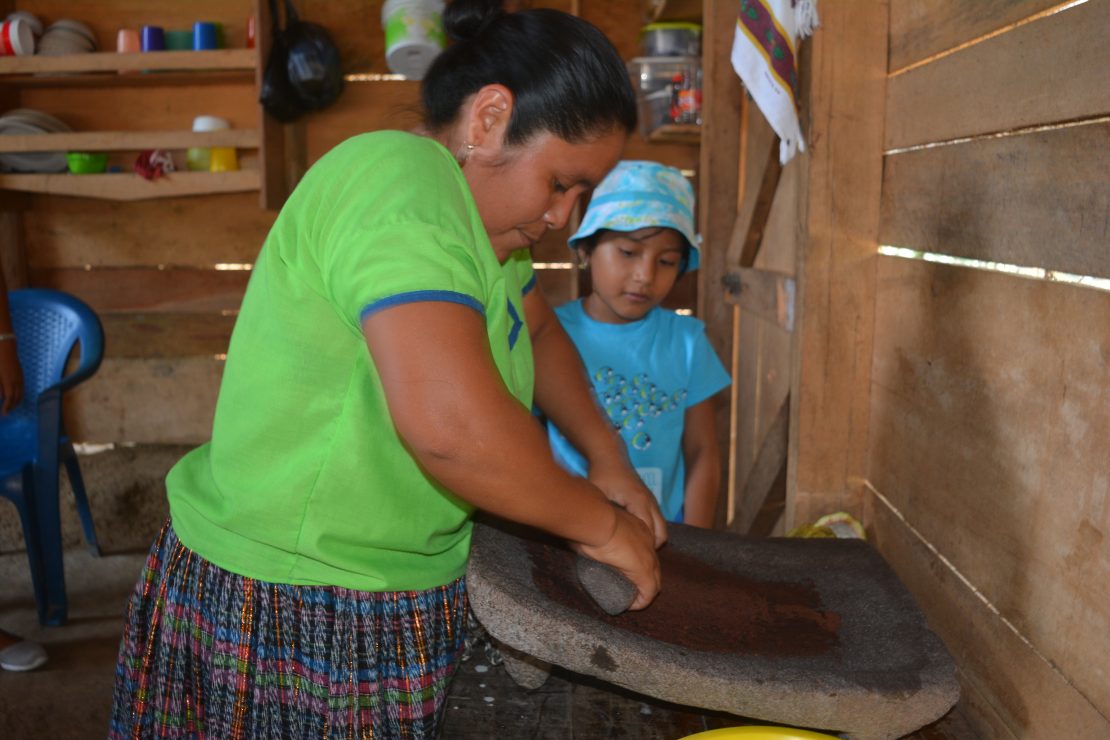 Woman grinding cacao beans in Belize